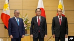 Philippine Foreign Secretary Teodoro Locsin, left, and Defense Secretary Delfin Lorenzana meet Japanese Prime Minister Fumio Kishida, center, at the official residence in Tokyo, Friday, April 8, 2022. (Kimimasa Mayama, Pool via AP)