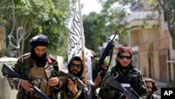 FILE - In this Aug. 19, 2021, photo, Taliban fighters display their flag on patrol in Kabul, Afghanistan.