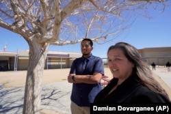 Mojave Unified School District Superintendent Katherine Aguirre, right, and Benito Luna-Herrera meet with his students, March 11, 2022. (AP Photo/Damian Dovarganes)