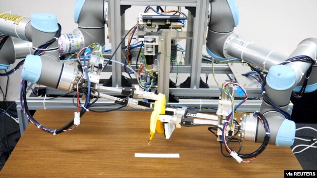 A dual-armed robot picks up a banana and peels it. Image taken December 2, 2021 and released by ISI (Kuniyoshi) Lab., School of Info. Sci & Tech., The University of Tokyo, Japan. (Handout via REUTERS)