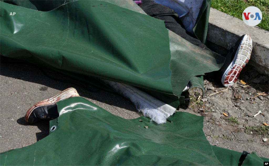 Cuerpos cubiertos con bolsas yacen en la calle después del ataque a la estación de tren de Kramatorsk, Ucrania.