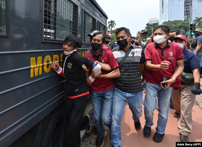 Polisi menangkap seorang pria saat unjuk rasa di Jakarta pada 11 April 2022. (Foto: AFP/Adek Berry)