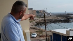 A Lebanese man points to the beach in Batroun, northern Lebanon, Nov. 2, 2024.