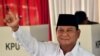 Presidential challenger Prabowo Subianto shows off his ink-dyed finger after casting his vote in Indonesia's general election at a polling station..