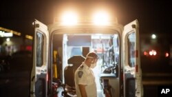 1일 미국 로드아일랜드주 크랜스턴에 설치된 새 임시 진료소에서 구급요원들이 앰뷸런스에 환자를 태울 준비를 하고 있다.