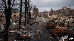 Un militar ucraniano camina entre tanques rusos destruidos en Bucha, en las afueras de Kiev, Ucrania, el miércoles 6 de abril de 2022. (Foto AP/Felipe Dana)