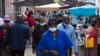Une femme portant un masque pour se protéger contre le coronavirus traverse la station de taxis animée de Bara à Soweto, Afrique du Sud, le 5 avril 2022.
