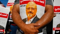 Varias personas con carteles con la imagen del periodista saudí Jamal Khashoggi se concentran cerca del consulado de Arabia Saudí en Estambul, el 2 de octubre de 2020, en el segundo aniversario de su muerte. 