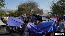 FILE - Migrants sent back to Mexico pass their time at an encampment yards away from the border in Reynosa, Mexico, April 1, 2022. 