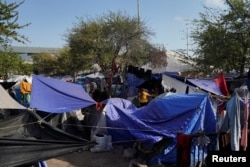FILE - Migrants sent back to Mexico pass their time at an encampment yards away from the border, while many hope to be allowed into the U.S. when Title 42 is lifted, in Reynosa, Mexico, April 1, 2022.