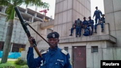 Des policiers congolais assis sur le bâtiment de la gare centrale, à Gombe, Kinshasa, en RDC, le 19 décembre 2016.