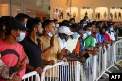 Buruh migran menghadiri acara yang menandai 200 hari jelang Piala Dunia FIFA 2022, di ibukota Qatar, Doha, 6 Mei 2022. (KARIM JAAFAR / AFP)