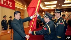 中共领导人习近平在北京举行的中国人民解放军战区成立大会上向火箭军将领、中国防长魏凤和（中）授予军旗。（2015年12月31日）
