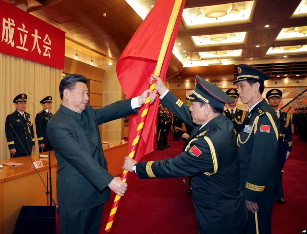 中共领导人习近平在北京举行的中国人民解放军战区成立大会上向火箭军将领、中国防长魏凤和（中）授予军旗。（2015年12月31日）(photo:VOA)