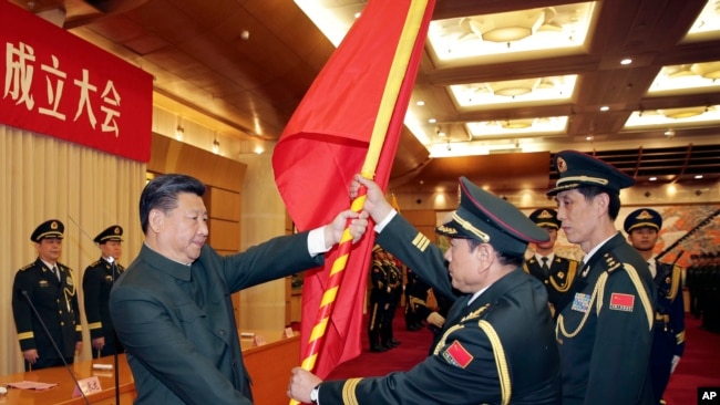 中共領導人習近平在北京舉行的中國人民解放軍戰區成立大會上向火箭軍將領、中國防長魏鳳和（中）授予軍旗。 （2015年12月31日）