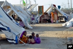 FILE - Children play outside their tent at a relief camp, in Jaffarabad, a district in the southwestern Baluchistan province, Pakistan, Sept. 29, 2022.