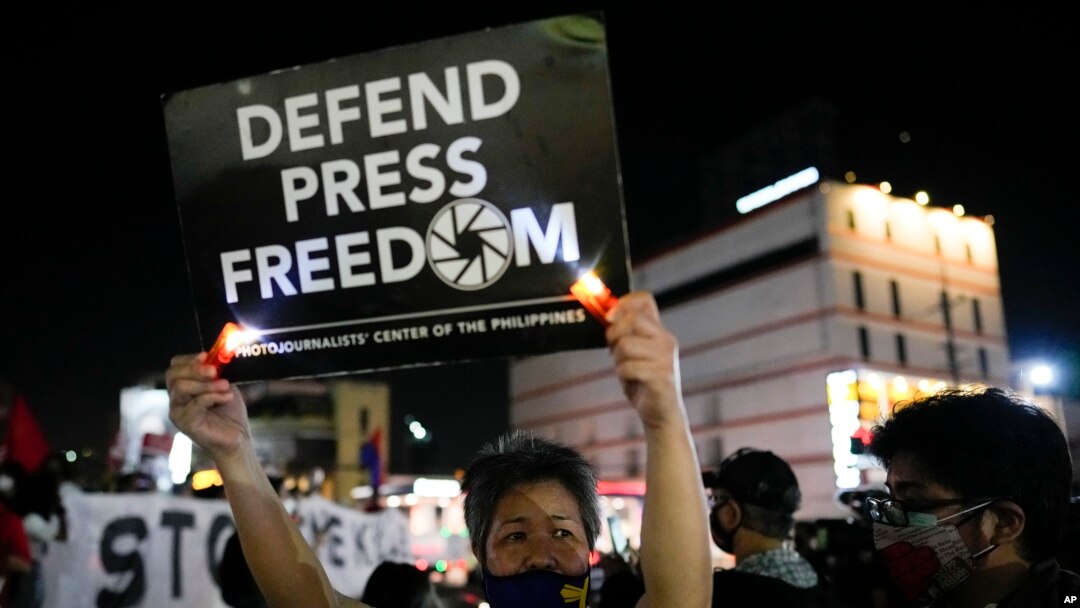 FILE - Activists hold slogans as they condemn the killing of Filipino journalist Percival Mabasa during a rally in Quezon city, Philippines, Oct. 4, 2022. 