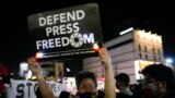 FILE - Activists hold slogans as they condemn the killing of Filipino journalist Percival Mabasa during a rally in Quezon city, Philippines, Oct. 4, 2022. 