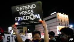 FILE - Activists hold slogans as they condemn the killing of Filipino journalist Percival Mabasa during a rally in Quezon city, Philippines, Oct. 4, 2022. 