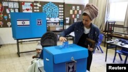 An Israeli woman casts her ballot on the day of Israel's general election in a polling station in Kiryat Arba, a Jewish settlement in Hebron in the Israeli-occupied West Bank Nov. 1, 2022.