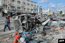 Destroyed cars litter the road Oct. 30, 2022, after a car bombing targeted the education ministry in Mogadishu on Oct. 29, 2022.