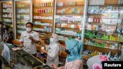 Petugas kesehatan memeriksa sirop obat yang mengandung ethylene glycol dan diethylene glycol di apotek di Bandung, provinsi Jawa Barat, 26 Oktober 2022. (Foto: Antara Foto/Raisan Al Farisi/via REUTERS)