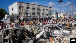 People walk amidst destruction at the scene, a day after a double car bomb attack at a busy junction in Mogadishu, Somalia, Oct. 30, 2022. 