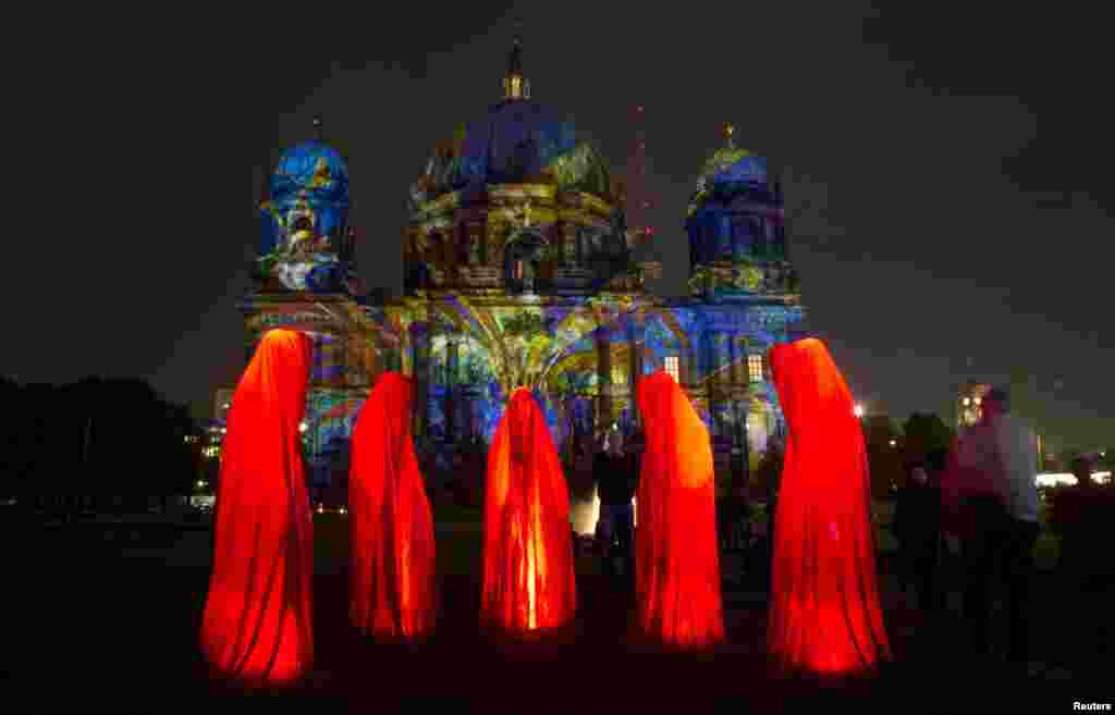 Warga setempat mengamati pemasangan lampu di Gereja Katedra, Berlin, yang menandai dimulainya Festival Cahaya "Festival of Light" di Berlin, 9 Oktober 2013. 