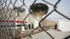 FILE - Guards stand at the entrance of Abu Ghraib prison on the outskirts of Baghdad, Iraq, Feb. 21, 2009. 