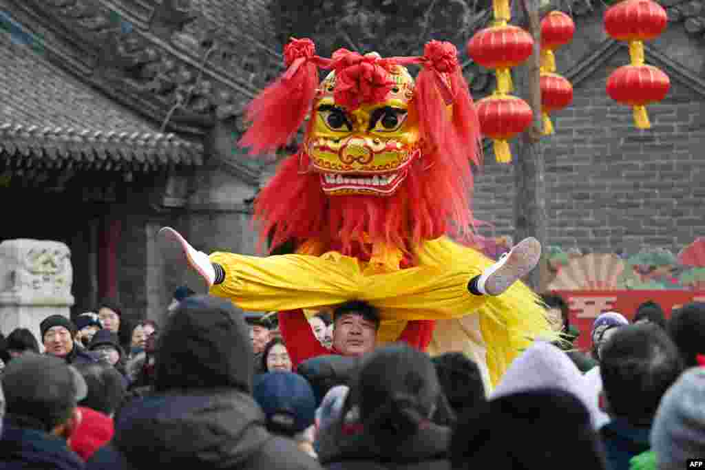 People watch lion dancers as they perform at a temple fair on the third day of the Lunar New Year of the Snake in Beijing.