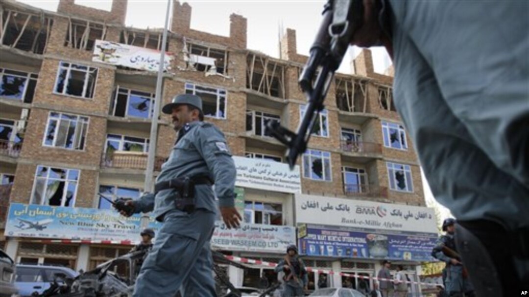 Seorang polisi Afghanistan melintasi bangunan yang digunakan sebagai basis pertahanan militan dalam serangan 18 jam di Kabul (16/4). Taliban mengaku bertanggungjawab atas serangan ini dan menamakan insiden ini sebagai 'bagian serangan musim semi' mereka.