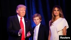 Presiden terpilih AS, Donald Trump, bersama putranya Barron dan istrinya Melania di Manhattan, New York (9/11). (Reuters/Carlo Allegri)