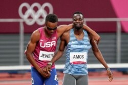 Isaiah Jewett, left, of the United States, and Nijel Amos, of Botswana, prop each other up after falling in the men's 800-meter semifinal at the 2020 Summer Olympics in Tokyo, Aug. 1, 2021.