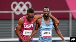 Isaiah Jewett, left, of the United States, and Nijel Amos, of Botswana, prop each other up after falling in the men's 800-meter semifinal at the 2020 Summer Olympics in Tokyo, Aug. 1, 2021.