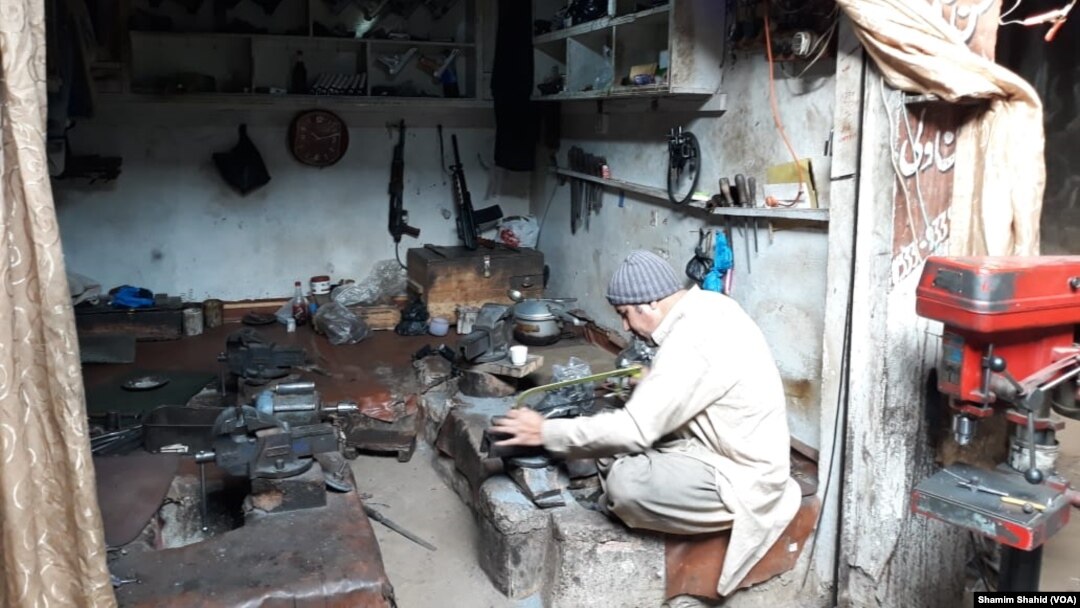 درہ آدم خیل میں ایک کاریگر بندوق بنانے میں مصروف ہے۔