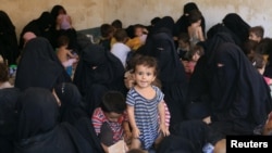 FILE - Families of Islamic State militants are seen after they surrendered themselves to the Kurdish Peshmerga forces in al-Ayadiya, northwest of Tal Afar, Iraq, Aug. 30, 2017.