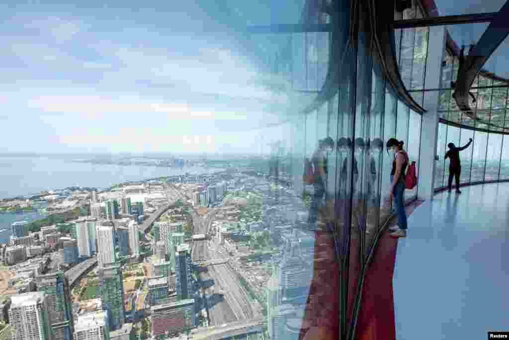 Visitors view panoramic city scenes from the 553-meter high (1,815 feet) CN Tower, which reopened for the first time since coronavirus pandemic restrictions were imposed, in Toronto, Ontario, Canada, July 15, 2020.