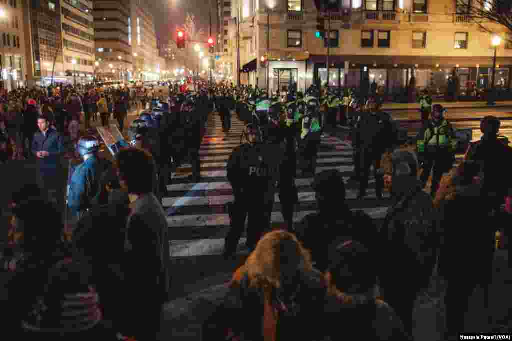 Sur la place Franklin, des militants anti-Trump se tiennent devant la police, à Washington DC, le 20 janvier 2017. (VOA/Nastasia Peteuil)