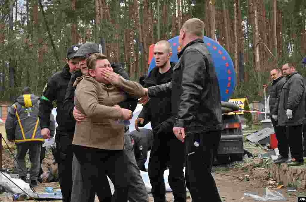 A Ukrainian mother reacts after the body of her son was discovered in a manhole at a petrol station in the outskirts of the Buzova village, west of Kyiv.&nbsp;At least two bodies, appearing to be clad in a mix of civilian and military clothing, were discovered in a manhole at the back of a destroyed motorway petrol station.&nbsp;