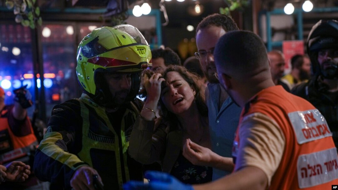 Seorang perempuan tampak menangis di lokasi penembakan di Tel Aviv, pada 7 April 2022. Penembakan terjadi di area bar dan restoran yang ramai pengunjung. (Foto: AP/Ariel Schalit)