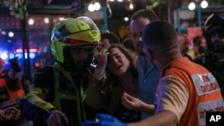 A woman reacts at the scene of a shooting In Tel Aviv, Israel, April 7, 2022. The shooting occurred in a crowded area with several bars and restaurants.
