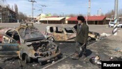 Un homme passe devant des voitures incendiées sur le site d'une frappe de missile, dans une gare, à Kramatorsk, en Ukraine, le 8 avril 2022.