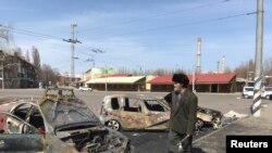 Seorang pria berjalan melewati mobil yang hangus terbakar kibat serangan misil di stasiun kereta api di Kramatorsk, Ukraina, 8 April 2022. (REUTERS/Stringer)