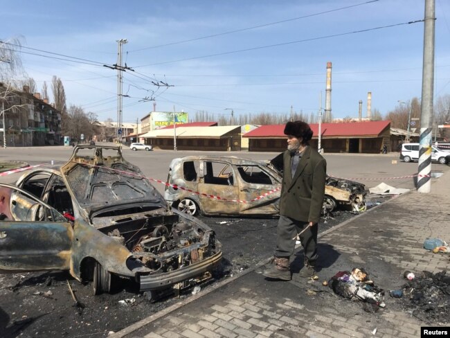 A man walks past burned cars at the site of a missile strike, at a rail station, amid Russia's invasion of Ukraine, in Kramatorsk, Ukraine April 8, 2022. REUTERS/Stringer