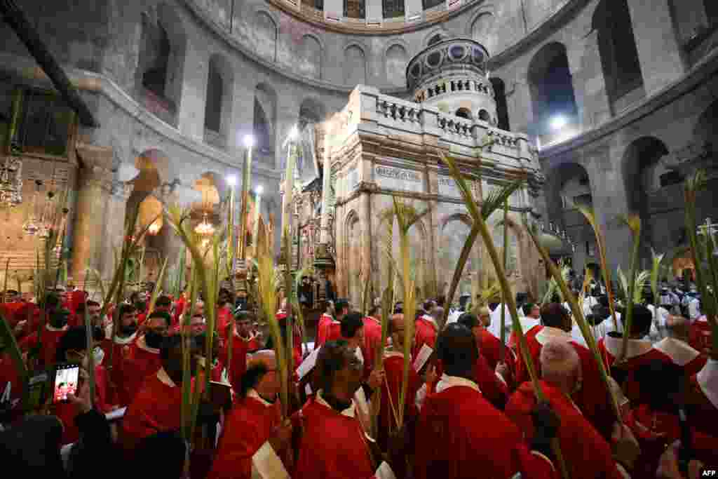 Roman Catholic clergy carry palm branches as they circle the aedicule during the Palm Sunday procession at the Church of the Holy Sepulchre in Jerusalem&#39;s Old City.