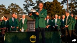 Scottie Scheffler holds the championship trophy after winning the 86th Masters golf tournament in Augusta, Georgia, April 10, 2022.
