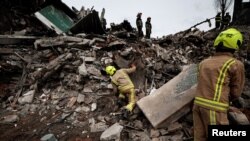 Rescuers search for bodies among remains of residential building destroyed by Russian shelling in Borodyanka, Kyiv region, Ukraine, April 10, 2022. 