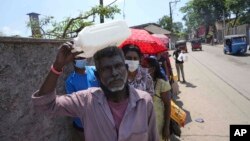 Sri Lankans queue up to purchase kerosene oil near a fuel station in Colombo, Sri Lanka, April 7, 2022. 