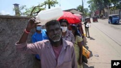 Sri Lankans queue up to purchase kerosene oil near a fuel station in Colombo, Sri Lanka, April 7, 2022.