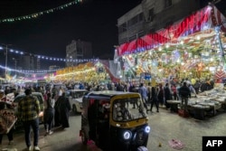 Sebuah tuk-tuk melewati pasar yang menjual lentera Ramadan dan dekorasi lainnya serta bahan makanan di distrik Sayyida Zeinab di ibu kota Mesir, Kairo, 30 Maret 2022, di tengah persiapan menjelang bulan suci Ramadan. (Khaled DESOUKI/AFP)